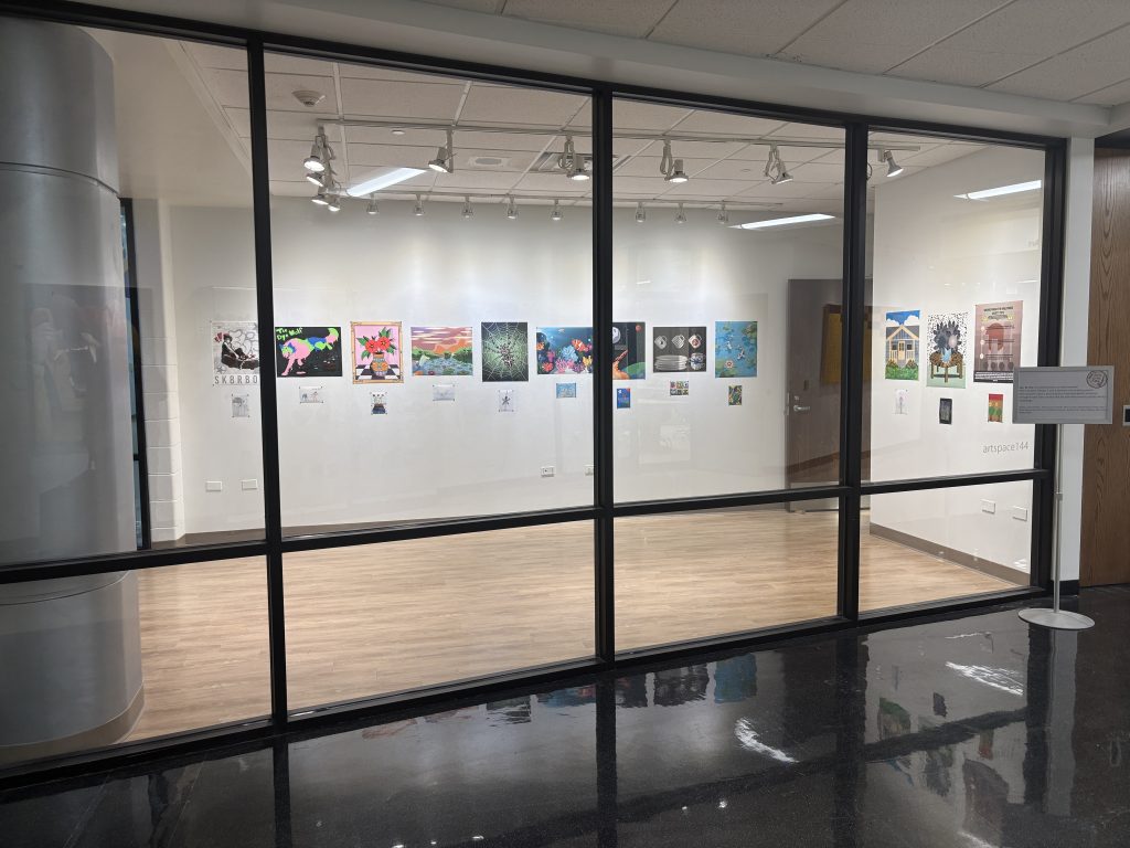 photo of an art exhibition room with several posters lined up on the wall